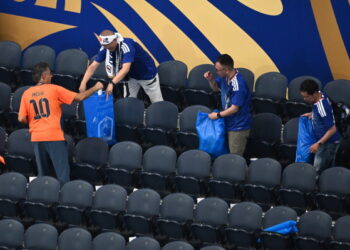 Japan fans clean up the stadium after the World Cup match against the Netherlands