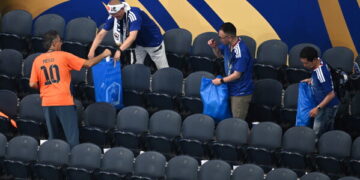 Japan fans clean up the stadium after the World Cup match against the Netherlands