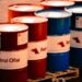 A collection of red and blue oil barrels labeled 'Petrol Ofisi' in an outdoor industrial setting in Turkey.